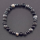 Bracelet with black and gray beads on a gray background