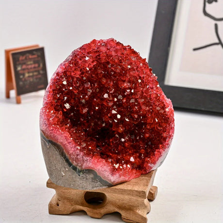 Red crystal geode on a wooden stand with a white background