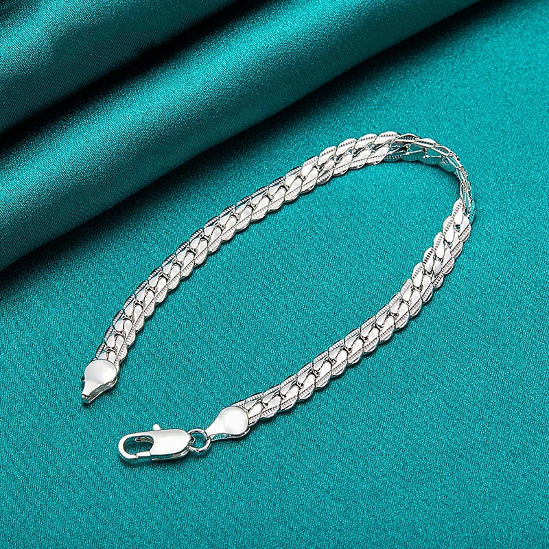 Silver chain bracelet on a teal fabric background