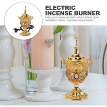 Gold electric incense burner on a white surface with decorative elements.