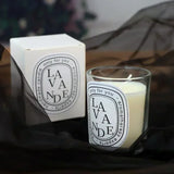 Lavender candle with packaging on a dark surface
