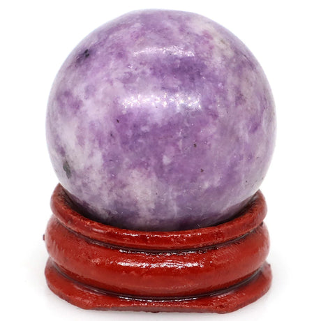 Purple crystal ball on a red stand against a white background