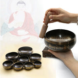 Tibetan singing bowls with a hand holding a bowl and a person in traditional attire in the background.