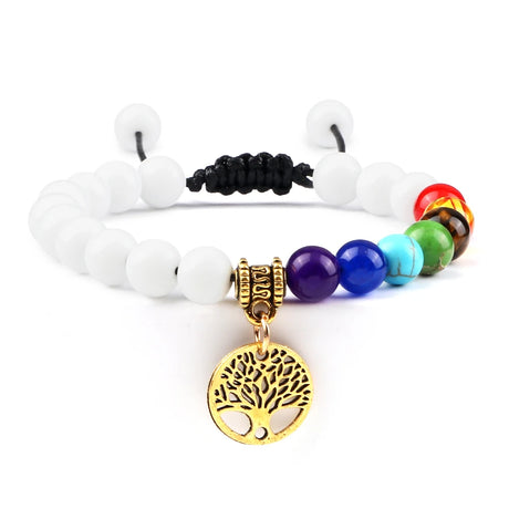 Bracelet with white beads, colorful beads, and a gold tree-of-life charm on a white background