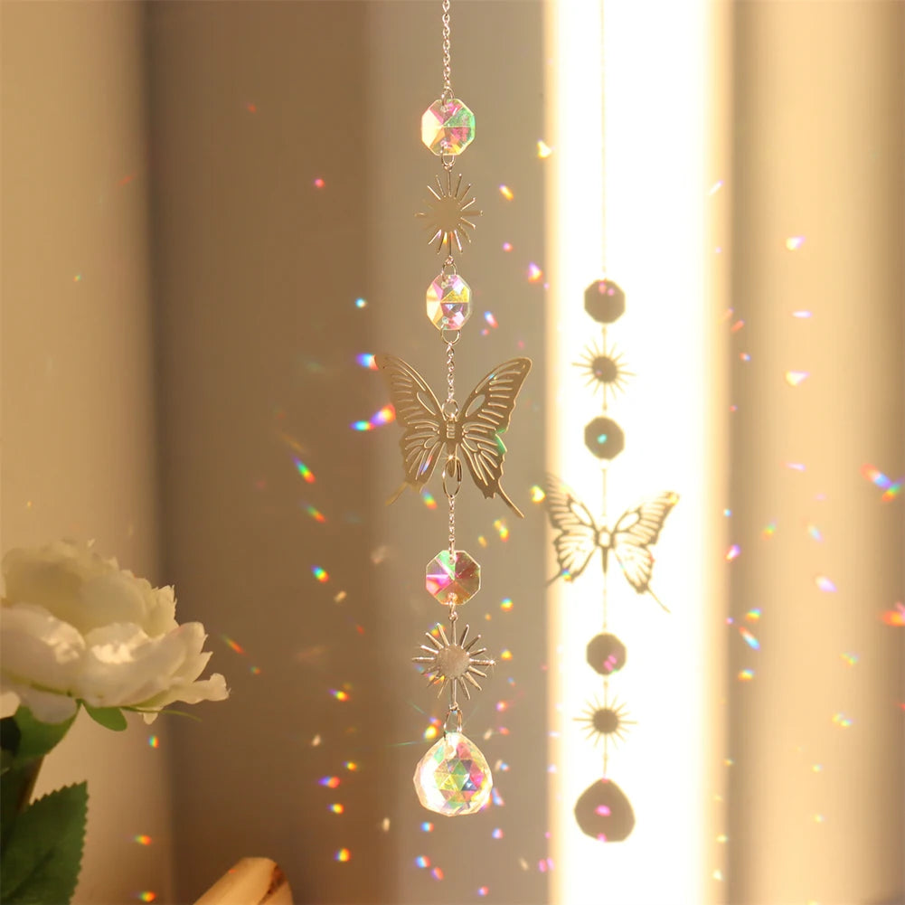 Butterfly-shaped crystal hanging ornament with rainbow, next to a white rose.