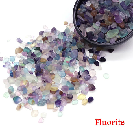 Multicolored fluorite stones with a bowl of stones on a white background