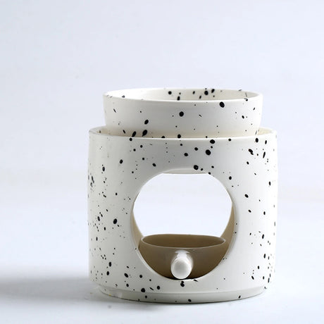 Speckled ceramic oil burner with a beige interior on a white background