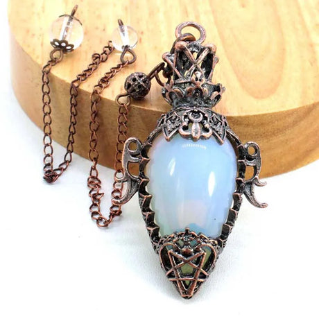 Ornate pendant with blue stone on a white background