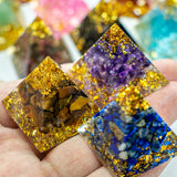 Colorful crystal pyramids held in a hand with blurred multicolored background