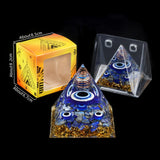 Pyramid-shaped object with blue and gold elements next to its packaging on a black background