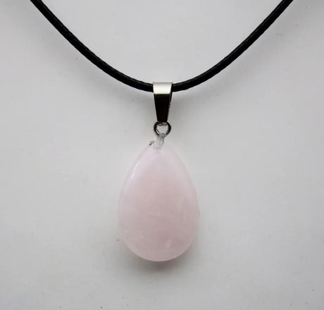 Pink teardrop pendant on a black cord against a white background