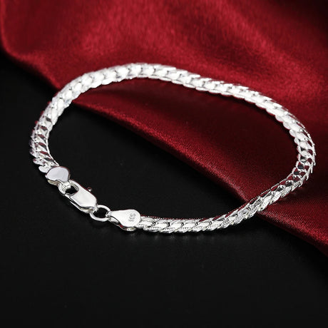 Silver bracelet on a dark surface with a red fabric background