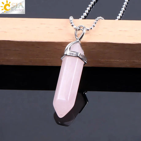 Pink crystal pendant on a silver chain against a dark background
