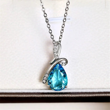 Teardrop-shaped blue gemstone necklace on a white background
