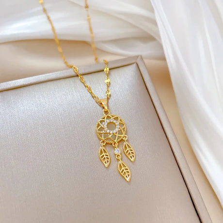 Gold necklace with a dreamcatcher pendant on a soft beige fabric background