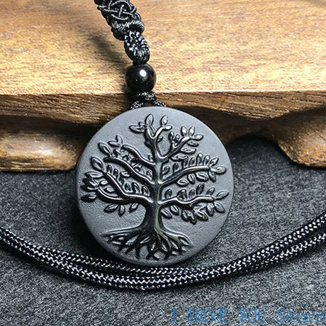 Necklace with a tree of life pendant on a wooden and stone background