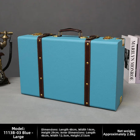 Blue suitcase with brown straps on a gray surface with a gray background