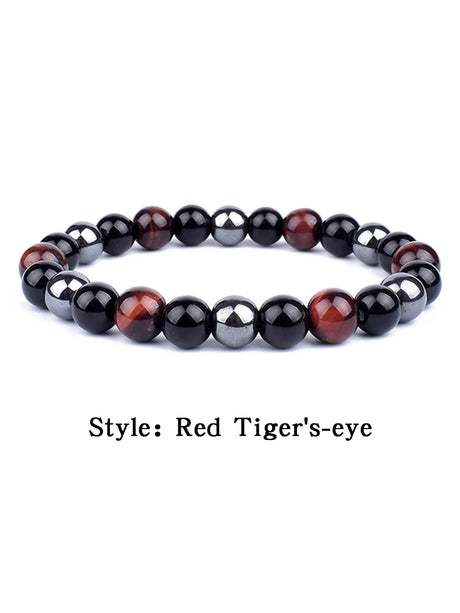 Beaded bracelet with red and black stones on a white background