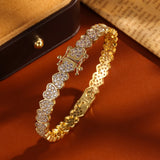 Gold bracelet with diamond accents on a brown surface