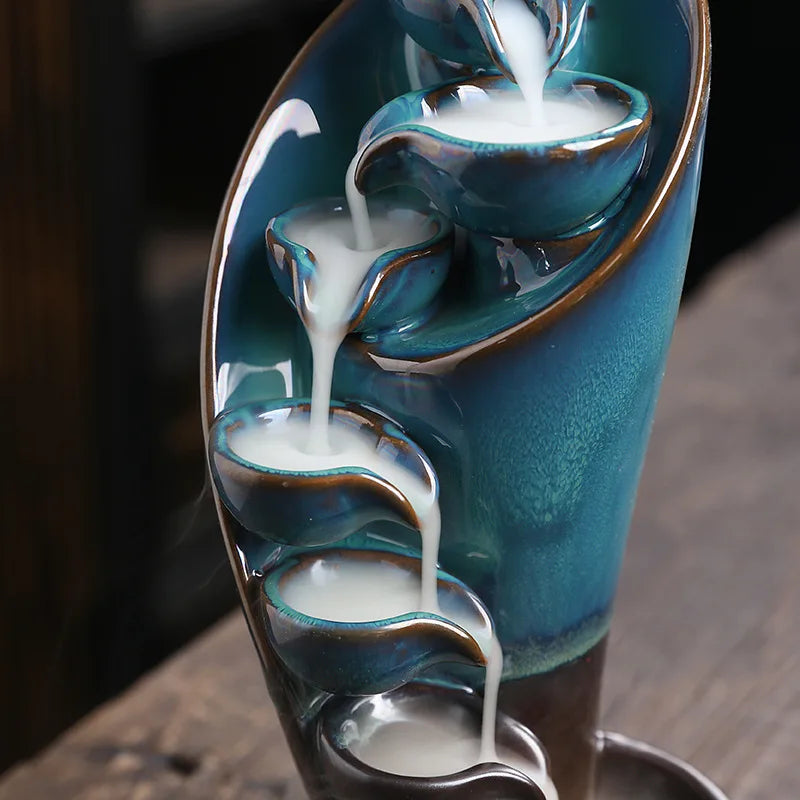 Ceramic water fountain with multiple tiers on a wooden surface