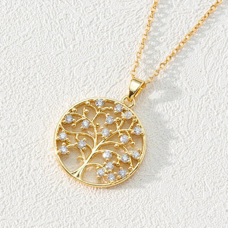 Gold necklace with a tree-of-life pendant on a light background