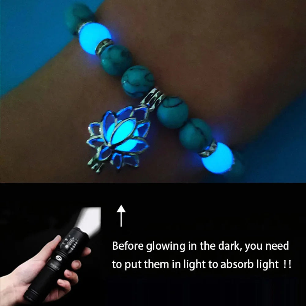 Bracelet with glowing blue lotus pendant on wrist, with a flashlight for light absorption.