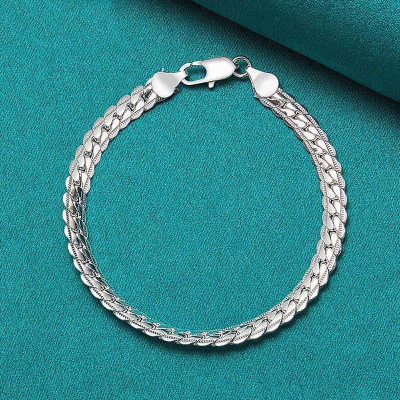 Silver chain bracelet on a teal background