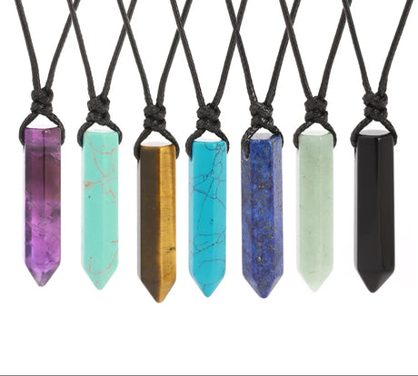 Set of crystal pendant necklaces on black cords with visible brand logo.