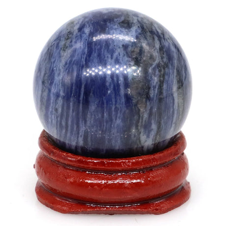 Blue and gray marbled sphere on a red stand against a white background