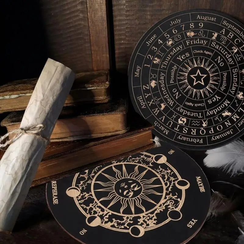 Two black circular items with celestial designs on a wooden surface with books and scrolls.