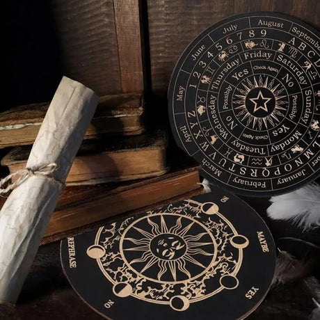 Two black circular items with celestial designs on a wooden surface with books and scrolls.