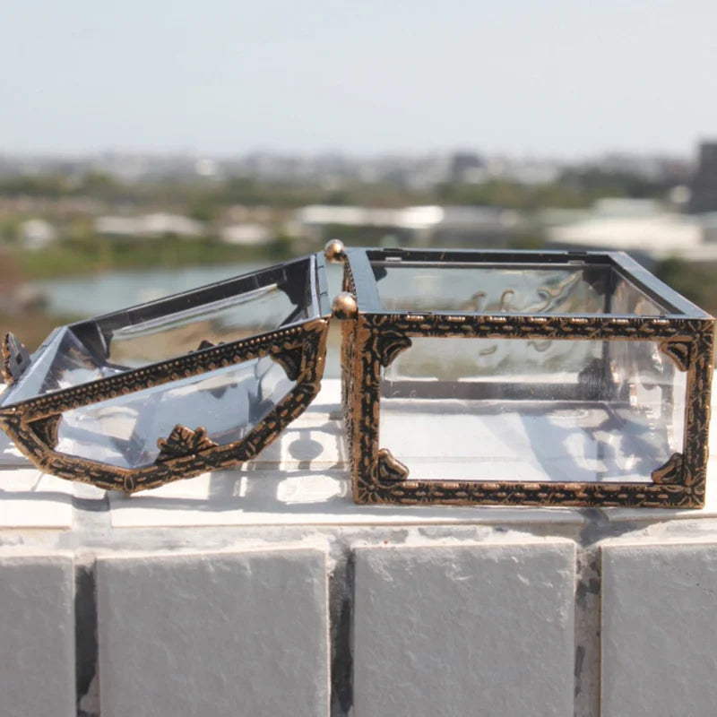 Decorative glass box with bronze frame on a ledge with a blurred cityscape background