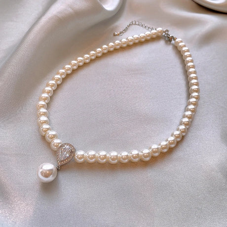 Pearl necklace with a decorative clasp on a light fabric background