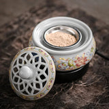 Decorative ceramic incense burner with floral patterns on a textured surface