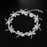 Silver bracelet with dragonfly designs on a black background