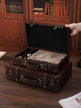 Vintage-style brown suitcase on a wooden floor with books in the background