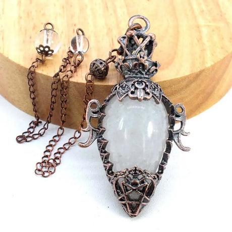 Decorative pendant with a clear stone on a wooden surface