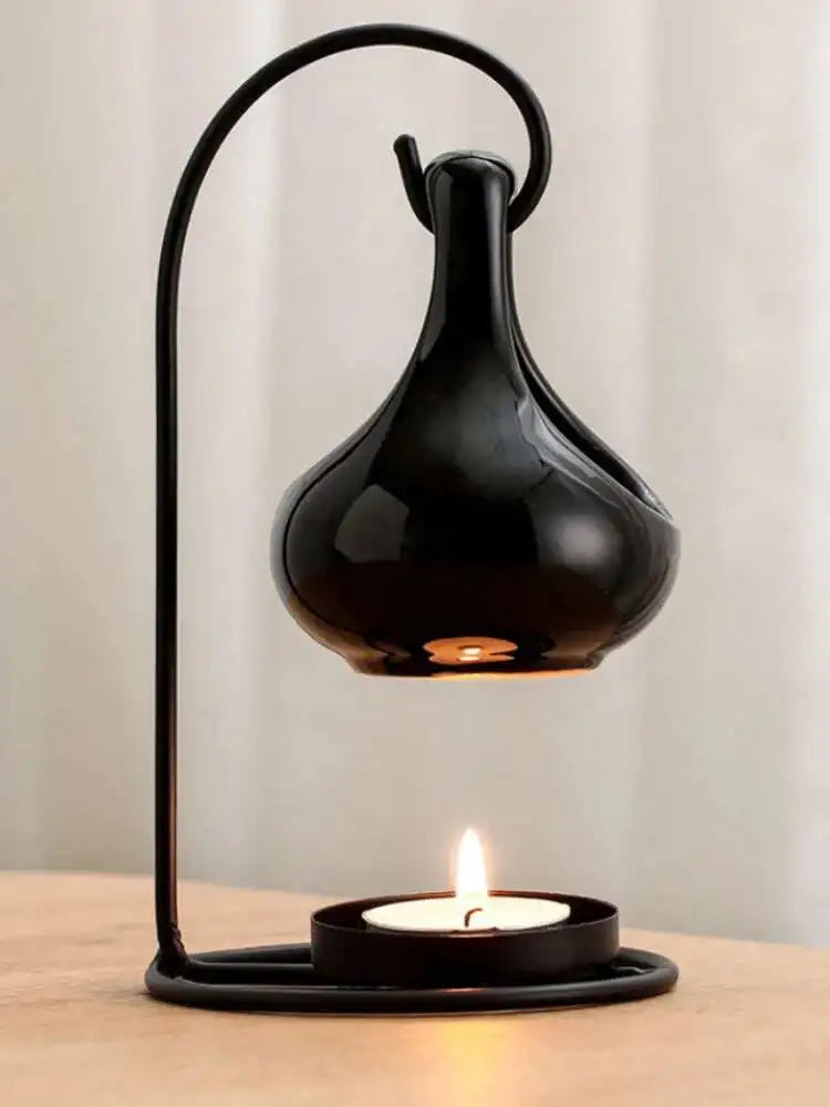 Black table lamp with a lit candle on a wooden surface