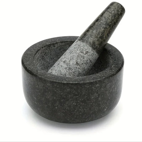 Black stone mortar and pestle on a white background