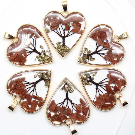 Heart-shaped pendants with tree designs on a white background