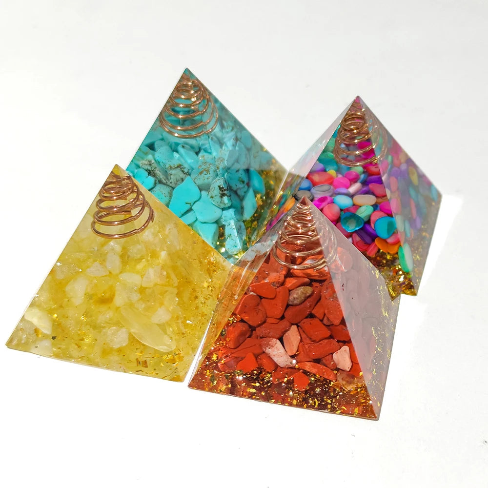 Three pyramid-shaped orgone energy generators with different colored stones and crystals on a white background.