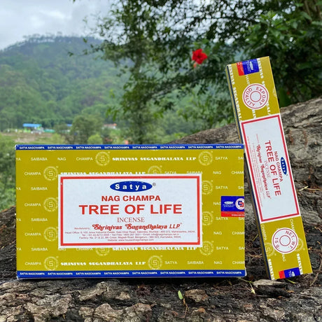 Satya Nag Champa Tree of Life incense packaging on a natural background with trees and mountains.