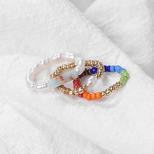 Set of colorful beaded rings on a white fabric background
