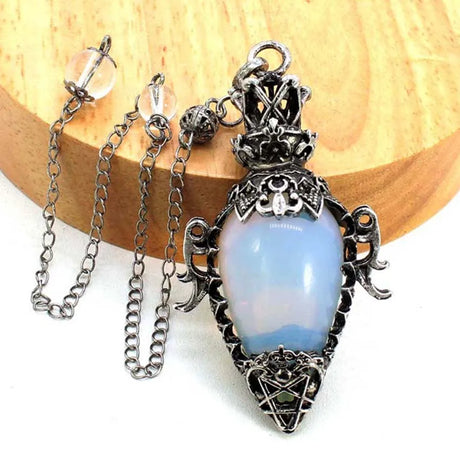 Decorative pendant with blue stone and silver chain on a wooden surface