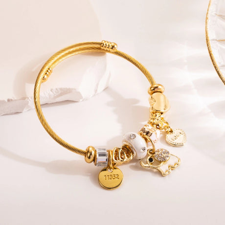 Gold bracelet with charms on a white background