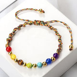 Colorful beaded bracelet with gold accents on a white background
