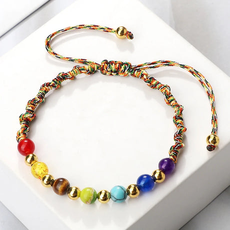Colorful beaded bracelet with gold accents on a white background