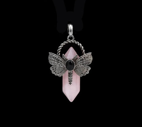 Pendant with butterfly design and pink crystal on a black background