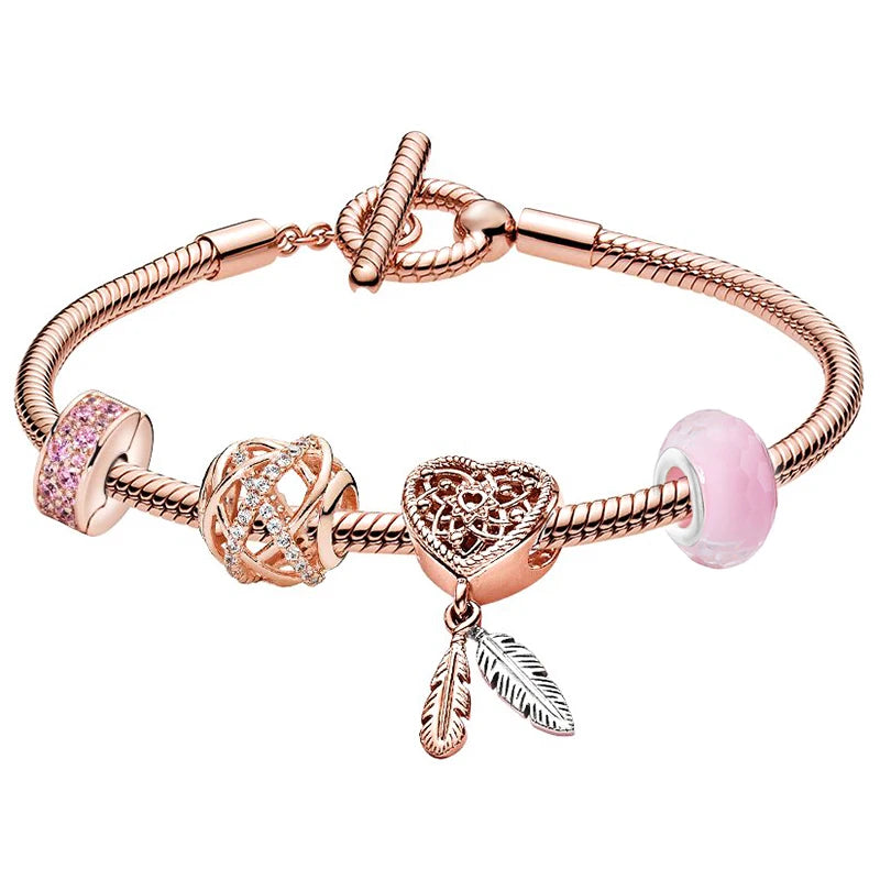 Rose gold bracelet with heart-shaped charm and pink beads on a white background