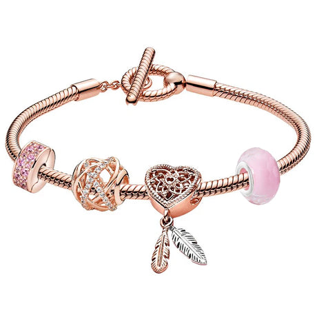 Rose gold bracelet with heart-shaped charm and pink beads on a white background